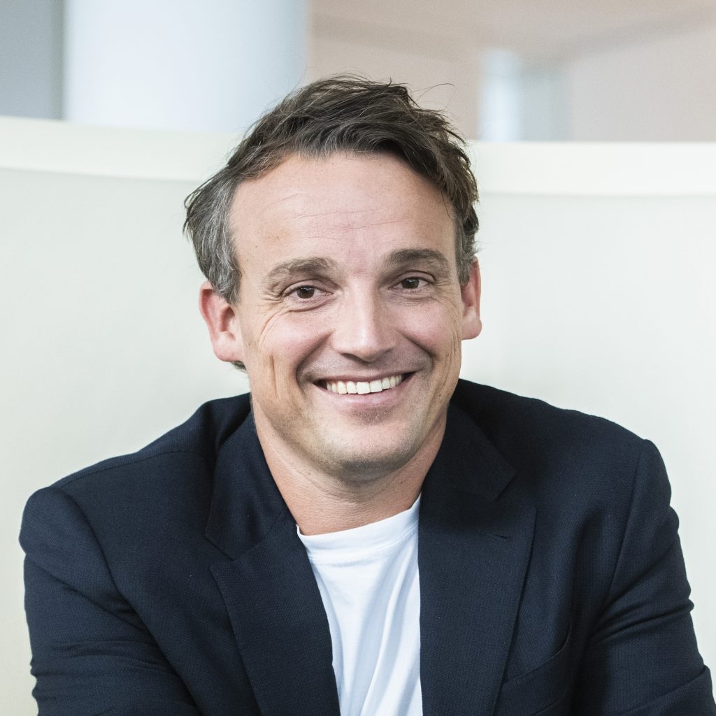 A man wearing a suit smiling at the camera