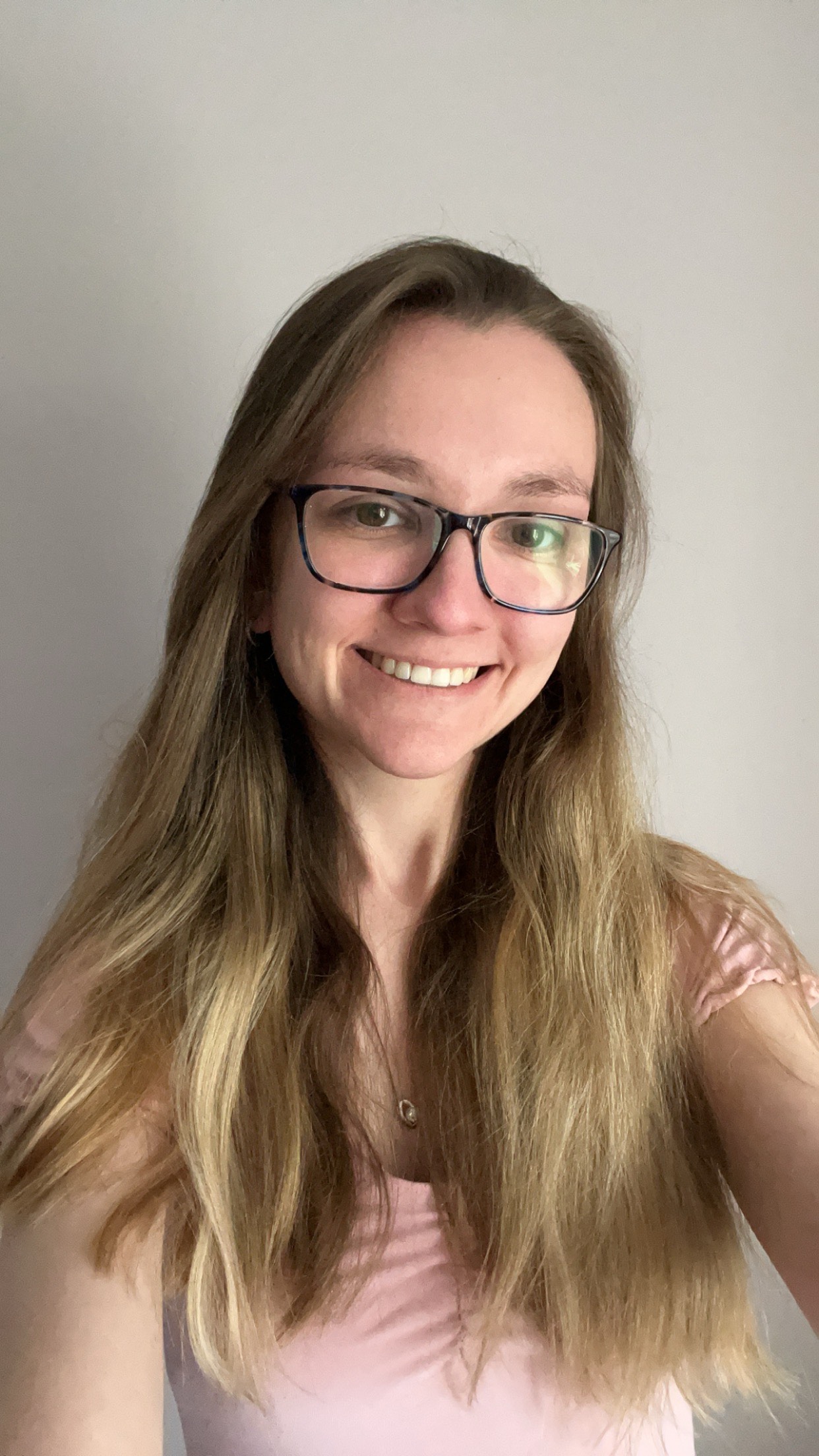 A young lady with glasses smiling