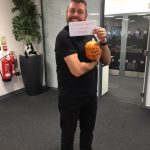 man holding what looks like pumpkin and a note