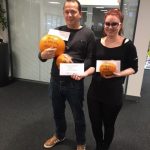 2 people holding what looks like pumpkins and a note
