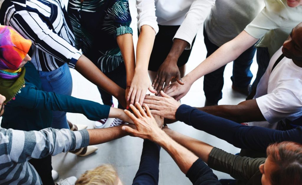 Equality & Diversion image of people putting their hands on each other